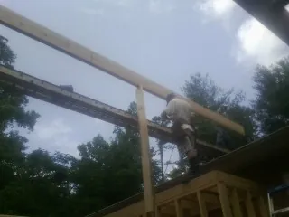 Carpenter setting a ridge beam over a new addition frame — Ice Dam Removal by Roofing Brothers in Beulah